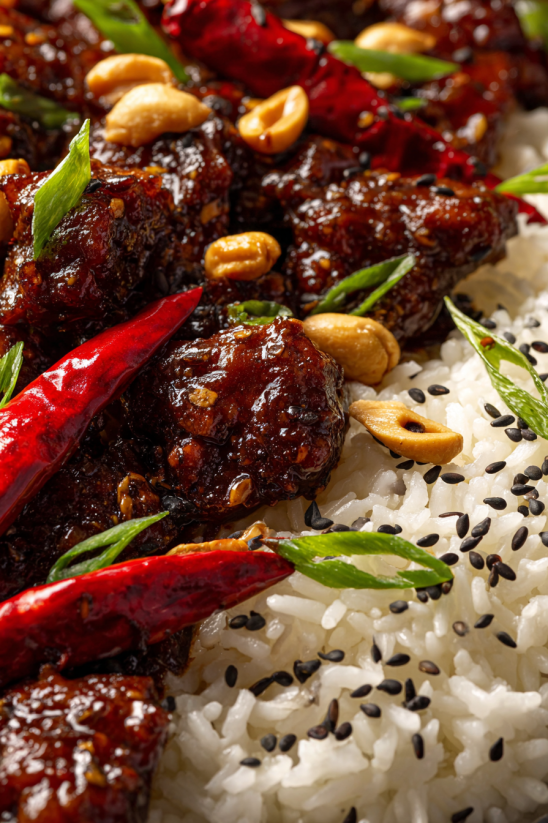 Ein Bild von Kung Pao Chicken, das aus Rindfleisch, Reis, Nüssen, Chili und Gewürzen besteht.