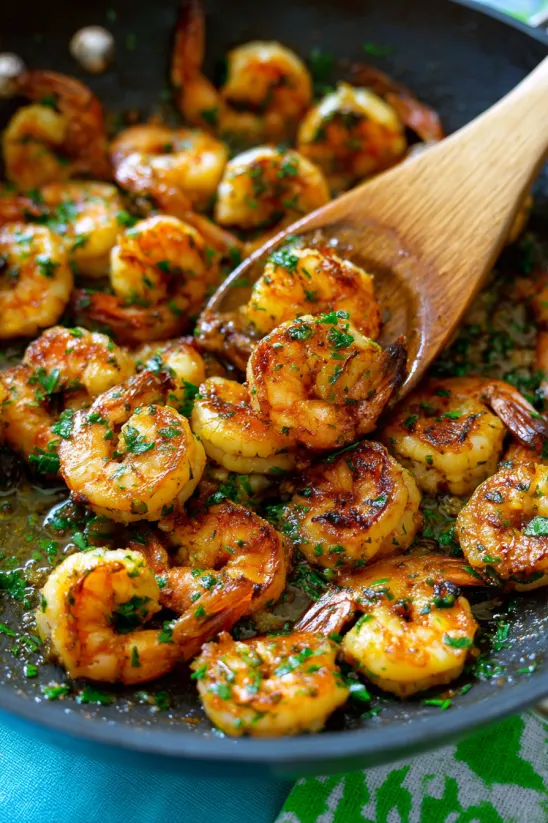 Eine Schüssel mit Cajun Shrimp, die in einer Pfanne mit Öl zubereitet wurden.