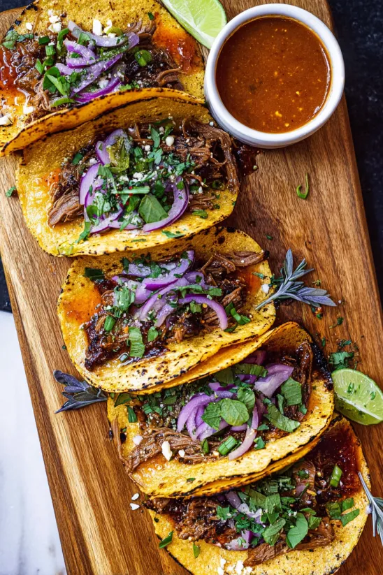 Ein Teller mit Tacos, gefüllt mit Fleisch und Zwiebeln.