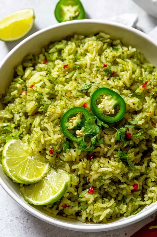 Ein Schälchen grüner Reis mit Paprika und Limette.