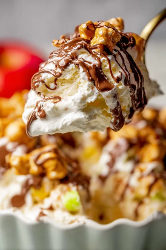 Nahaufnahme von Snickers-Apfelsalat mit Karamell.