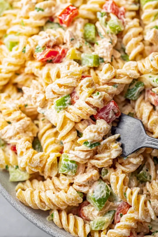 Eine Gabel steckt in einer Schüssel Thunfisch-Nudelsalat.