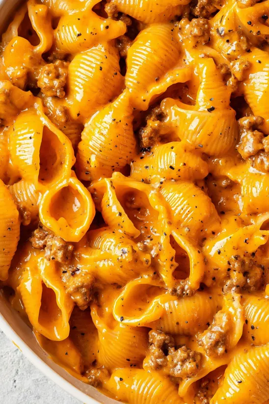 Eine Schüssel Makkaroni mit Käse und Fleisch obendrauf.