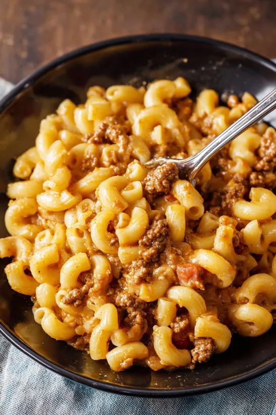 Eine Schüssel Hamburger Helper mit Löffel drin.