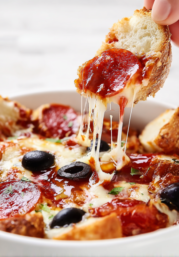 Ein Stück Pizza wird in eine Schale mit Soße gedippt.