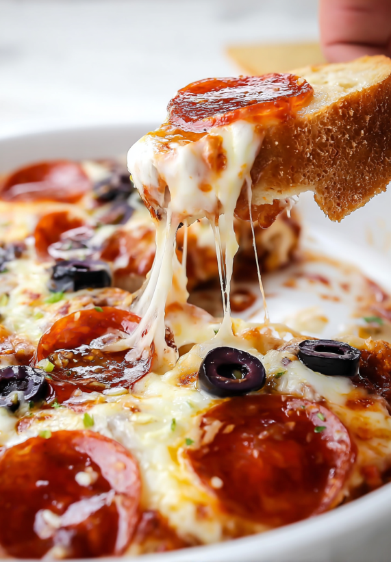 Ein Stück Pizza voll mit Fädenkäse und schwarzen Oliven.