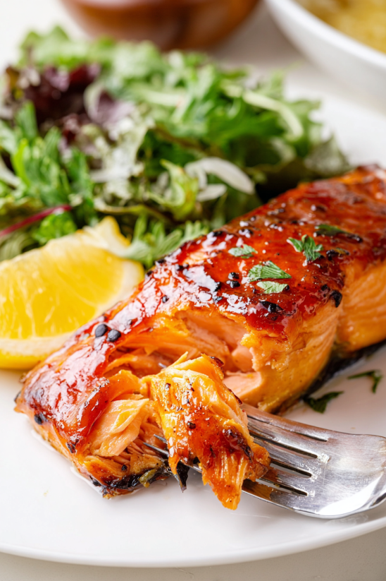 Ein Salmonfilet auf einem Teller, gegrillt und mit Zwiebeln und Knoblauch garniert.