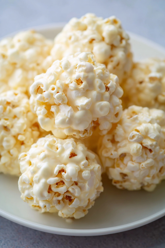 Ein weißer Popcorn Ball mit einer Kugelform und einer goldenen Farbe.