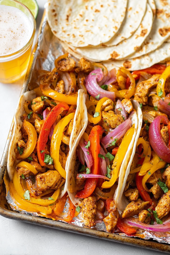 Eine Schüssel mit Chicken Fajitas auf einem Teller.