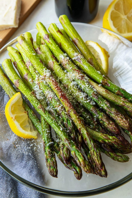 Ein Stück Asparagus mit Parmesan-Sauce auf einem Teller.