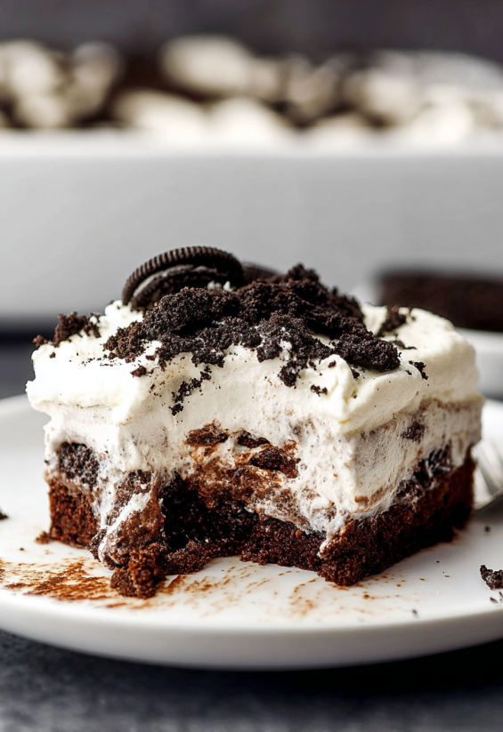 Ein Stück Oreo Pudding Poke Cake auf einem weißen Teller.