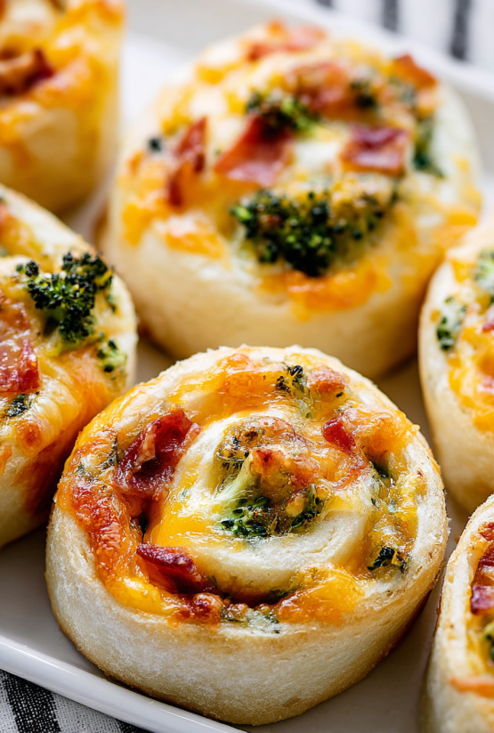 Ein Bild von Spiral Stuffed Rolls, die in einer Schüssel auf einem Tisch liegen.