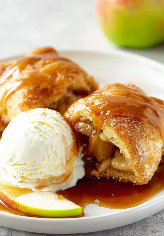 Ein Plate mit Apple Dumplings, die mit Sauce und Eis serviert werden.