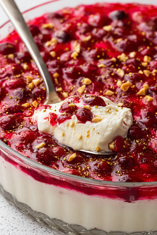 Eine Schüssel mit Cranberry Jello Salat und einer Kremchees-Topping.