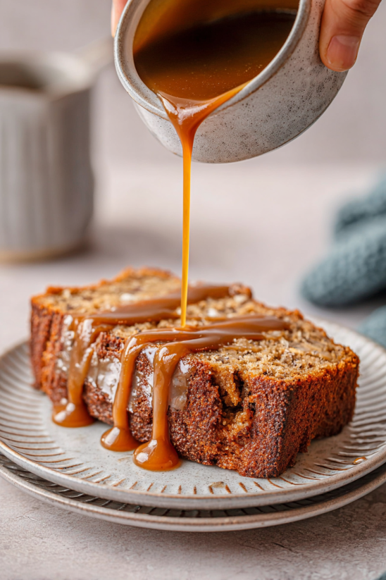 Ein Stück Bananenbrot, das mit Salz und Karamell sauert, auf einem Teller.