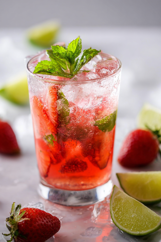 Ein Glas Strawberry Mojito Recipe mit Strawbergen und Mint.