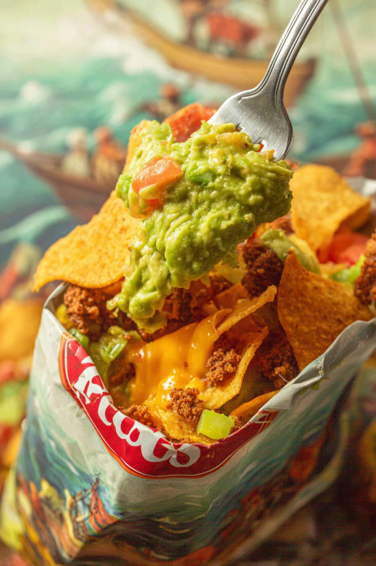 Ein Taco mit Avocado und Tomaten, der in einem Pappkarton serviert wird.