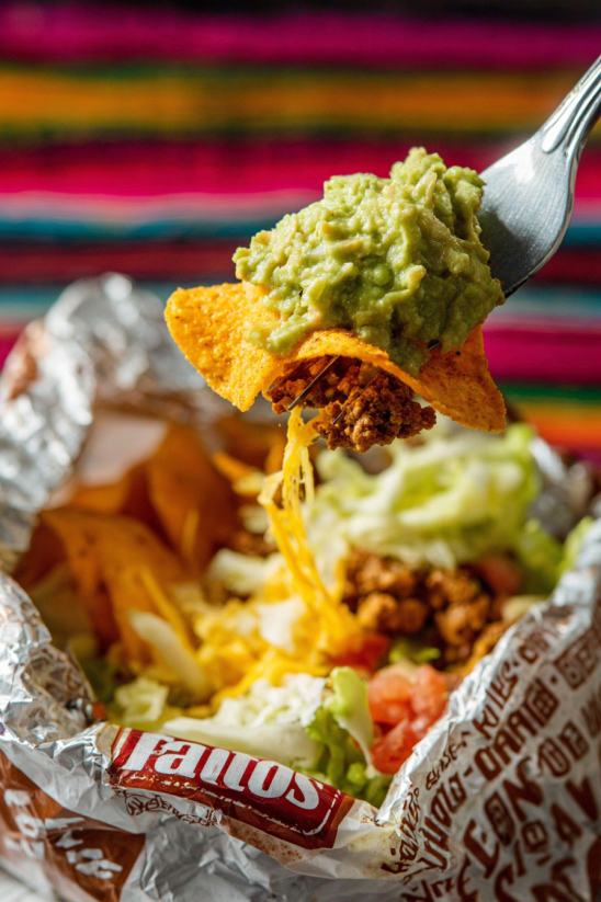 Ein Taco mit verschiedenen Zutaten wie Tomaten, Lettuce, Avocado und Tostada.