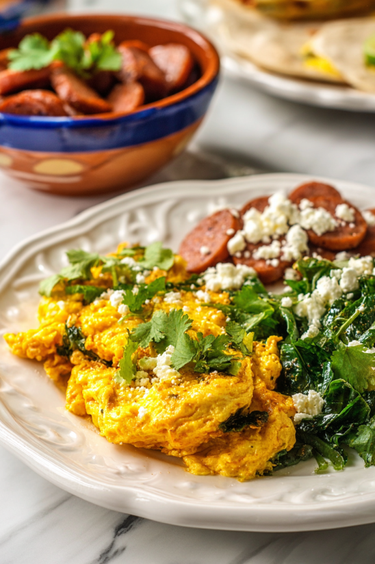 Ein wei&szlig;er Teller mit Huevos a la Mexicana (Scrambled Mexican Eggs) garniert mit gr&uuml;nen Zwiebeln.