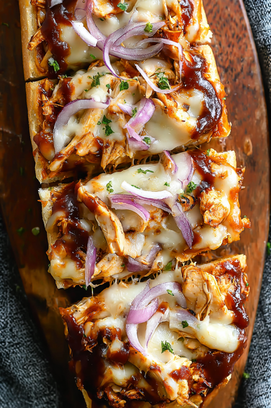 Eine Schicht aus BBQ Chicken auf einem French Bread Pizza.