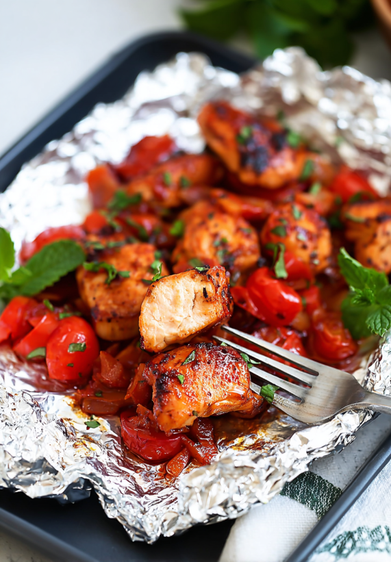 Ein Foil-Pack mit BBQ-Chicken auf einem Teller.