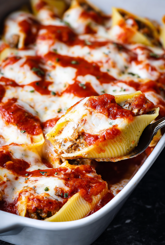 Eine Pizza-Stuffed Pasta Shells, die in einem weißen Teller serviert werden.