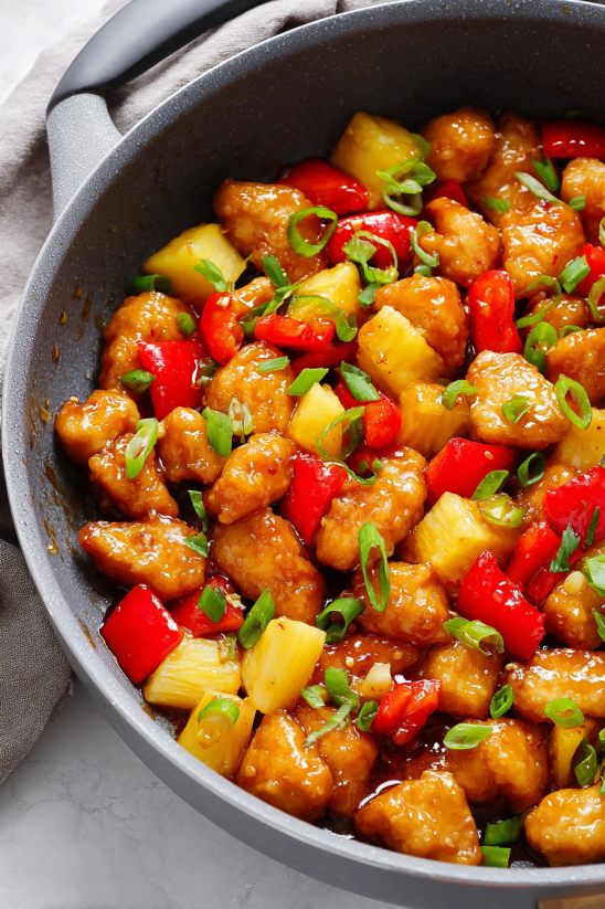 Ein Schalen mit Sweet Fire Chicken, das eine Mischung aus Zwiebeln, Papaya, Pineapple, Chili und Zucker ist.