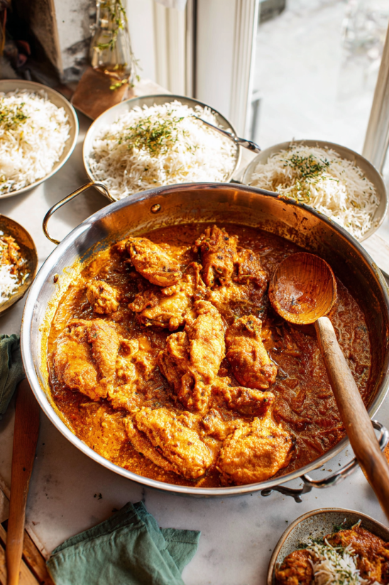 Ein Kessel mit Achiote Chicken, das in einem Topf auf einem Tisch steht.