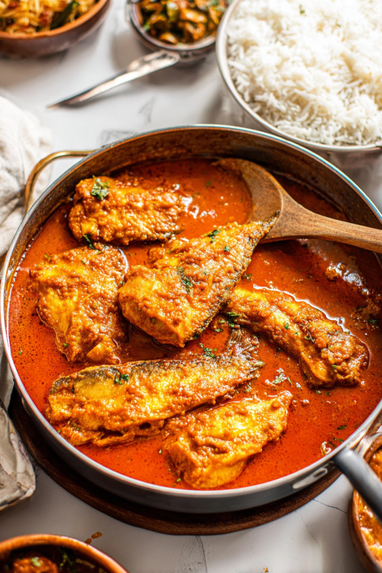 Ein Kessel mit Achiote Chicken, das in einer Rotsoße serviert wird.
