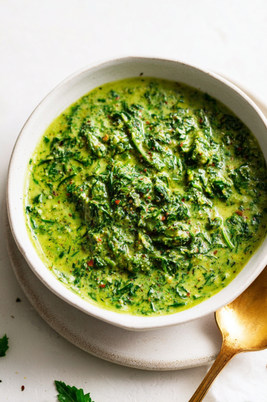 Ein weißer Teller mit einer grünen Sauce, die als Best Chimichurri Sauce bezeichnet wird.