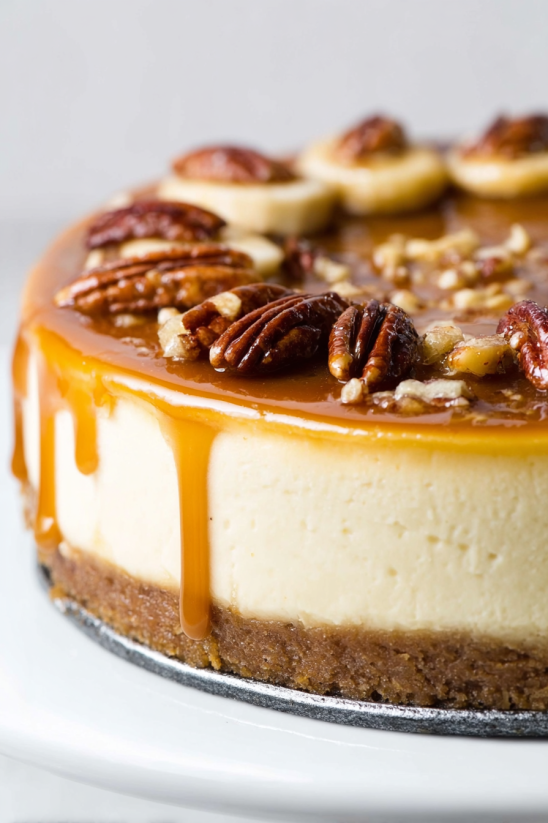 Eine Bananas Foster Cheesecake mit Bananen, Walnüssen und Gewürzen auf einem Teller.