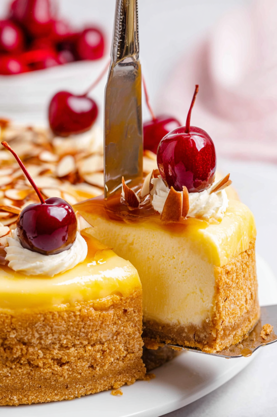 Ein Stück Almond Amaretto Cheesecake mit Cherry-Topping auf einem Teller.