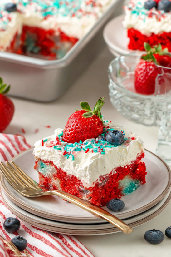 Eine Schüssel mit einem Stück Cake, das mit Strawberries und Blueberries garniert ist.