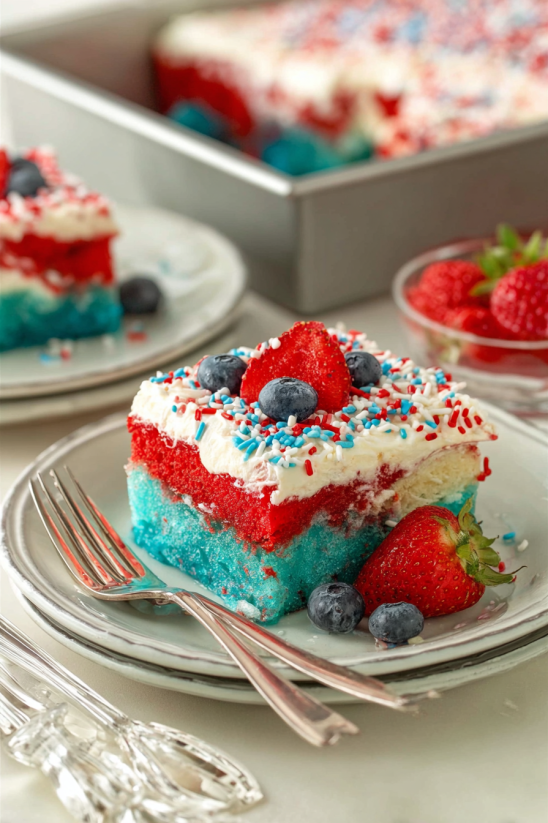 Ein Cake mit den Farben Rot, Blau und Grün, der mit Strawberries und Blueberries garniert ist.