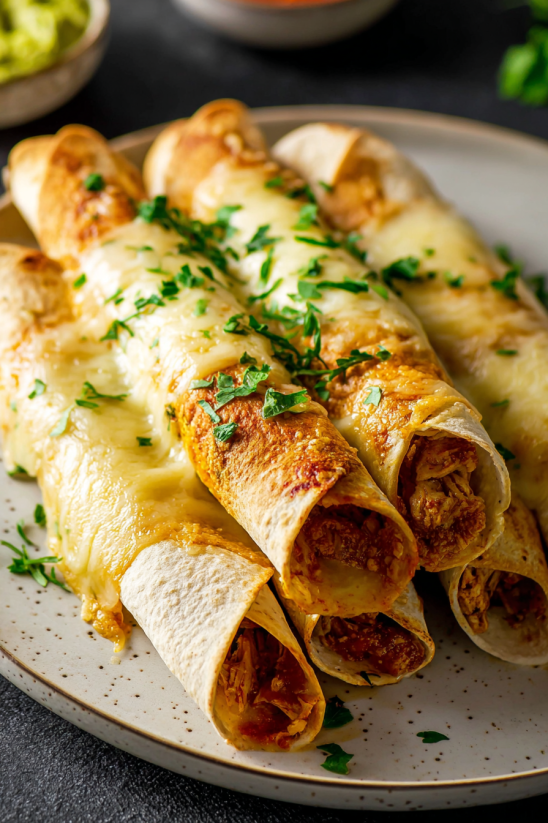 Eine Platte mit Cheesy Beef Flautas (oder Beef Taquitos) auf einer Tafel.