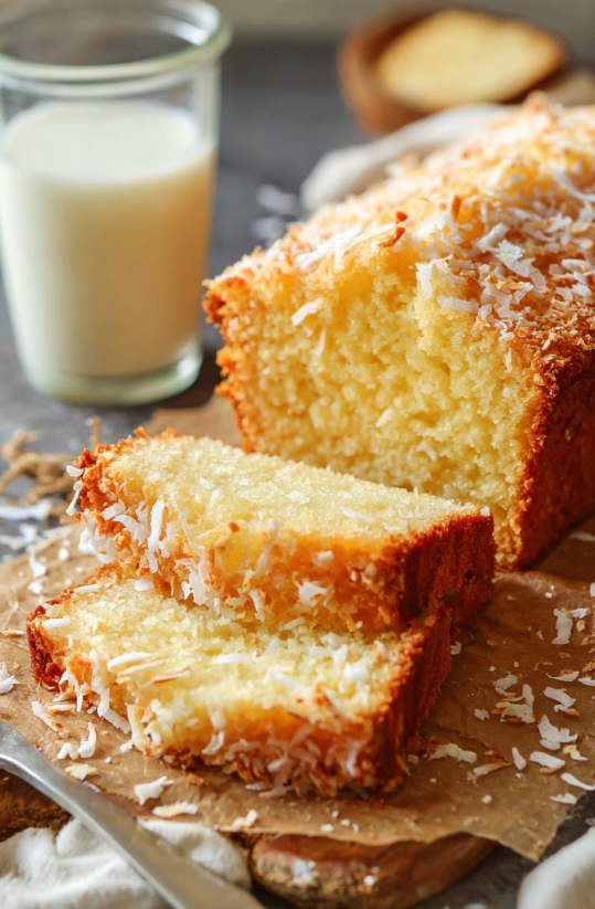 Ein St&uuml;ck von einem leckeren Pineapple Coconut Quick Bread, der in einer Sch&uuml;ssel mit Milch serviert wird.