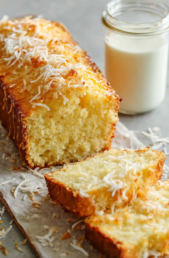Ein Stück Easy Pineapple Coconut Quick Bread, der in Stücke geschnitten wurde, auf einer Platte.
