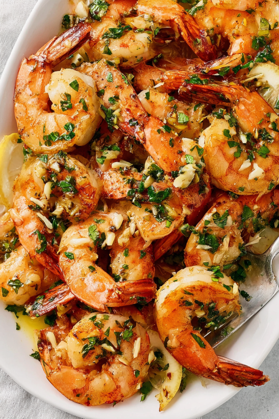 Ein Bild von Camarones al Ajillo (Garlic Shrimp) mit vielen verschiedenen Shrimp-Arten, die in einer Schüssel oder einem Becher serviert werden.