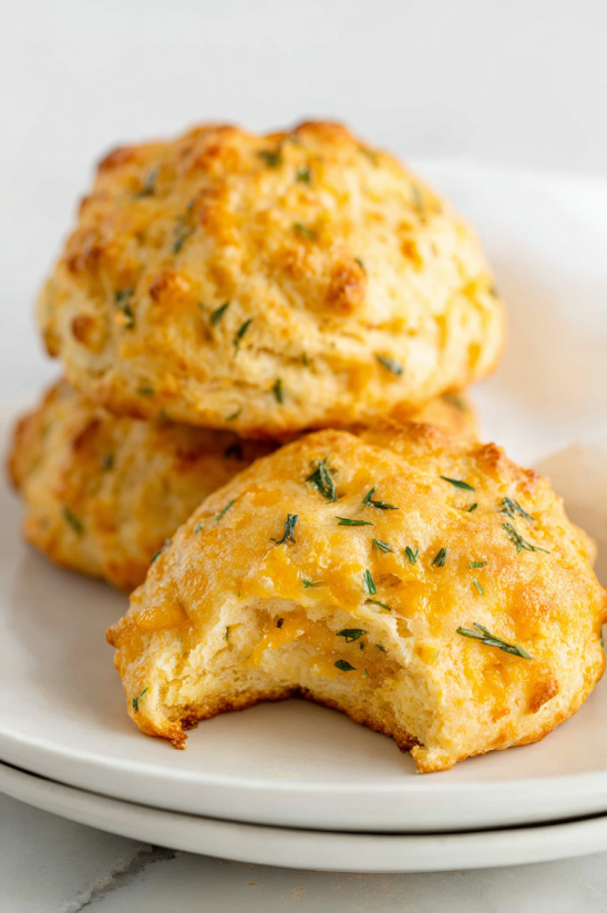 Zwei Biskuits mit Garlic Cheddar Zutaten auf einem weißen Teller.