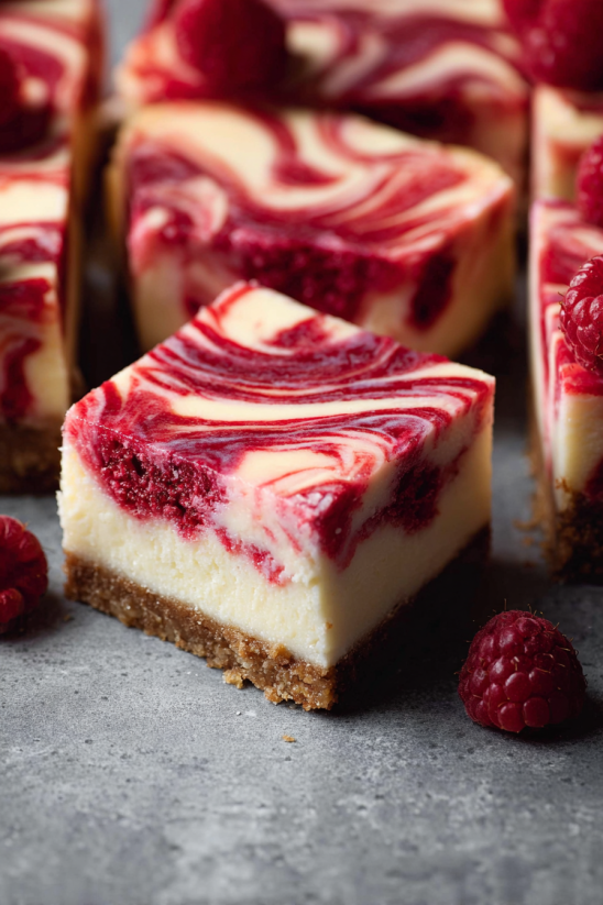 Ein Stück Easy Creamy White Chocolate Raspberry Cheesecake Bars.