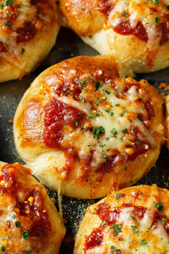 Eine Schicht von Tomaten-basierter Sauce bedeckt die Mini-Deep-Dish-Pizzas.