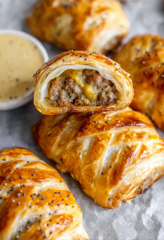 Ein Rezept f&uuml;r Sausage-Rolls, die in einer Sch&uuml;ssel mit Sauce gegeben werden.