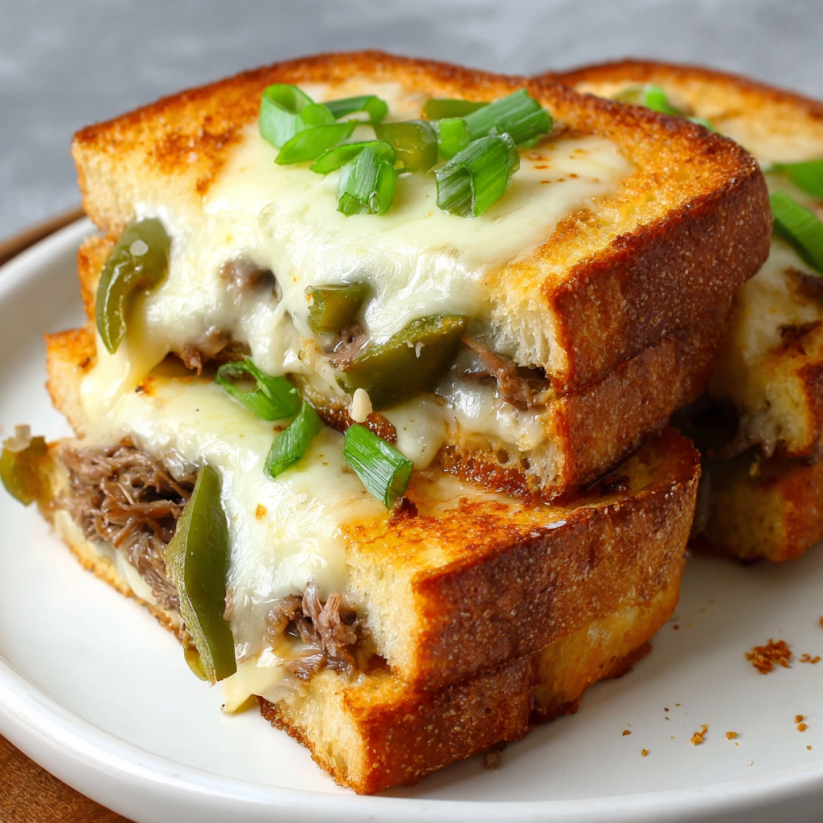Ein weißer Teller mit zwei Scheiben Toast, die mit Käse und grünen Zwiebeln garniert sind.