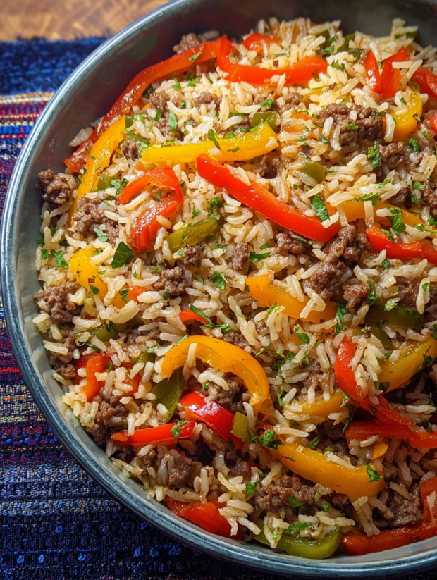 Ein Becher mit Rice und Gemüse, darunter Paprika, Zwiebeln und Tomaten.