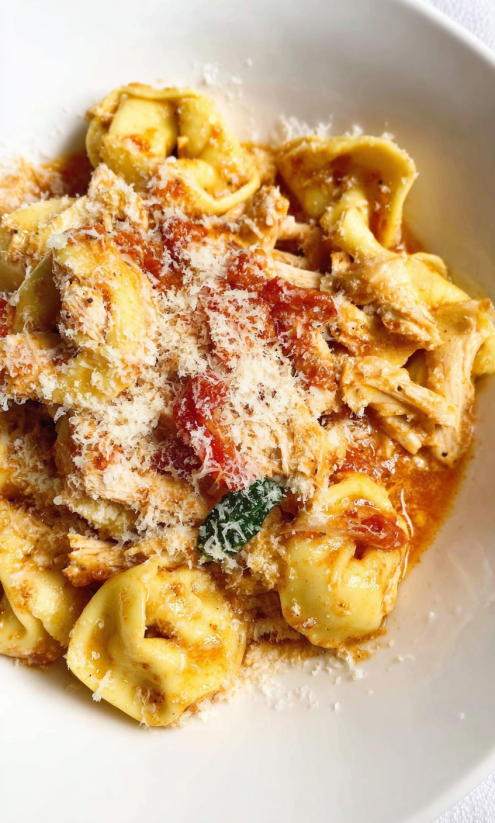 Ein Bild von Tortellini mit Sauce und Tomaten, das als "Slow Cooker Marry Me Tortellini" interpretiert werden kann.