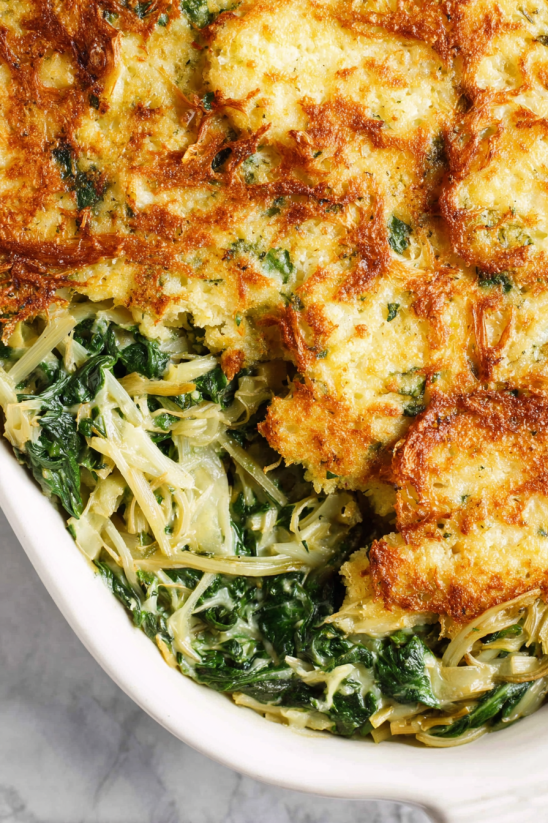 Ein Bild von einer Monterey Chicken Spaghetti Bake, die in einem weißen Behälter auf einem Tisch präsentiert wird.