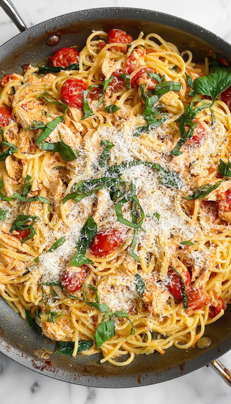 Ein Bild von einer Pasta-Gerichte, die mit Tomaten, Zwiebeln und Käse zubereitet wurde.