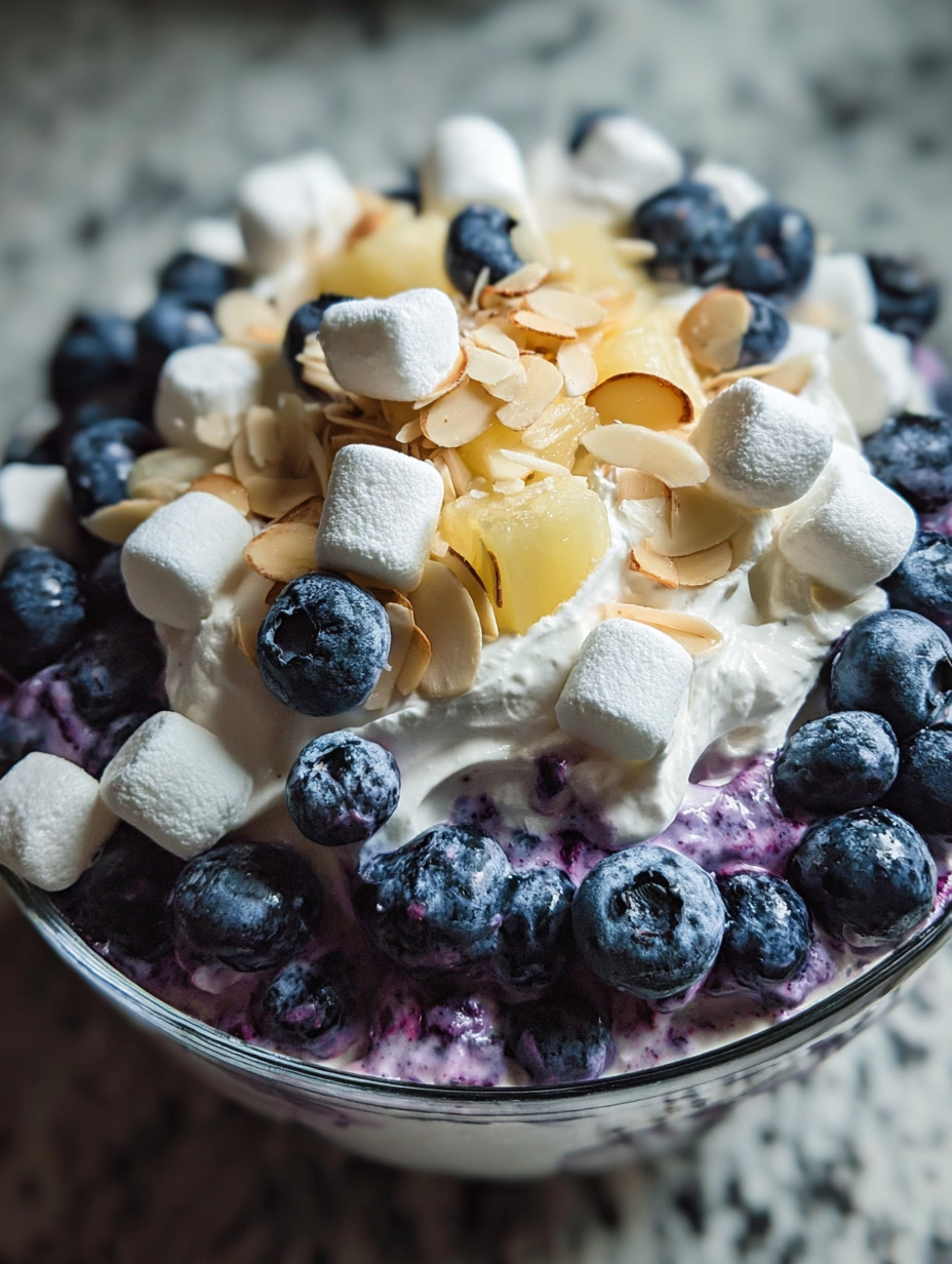 Ein Glas mit einer Mischung aus Marshmallows, Blueberries und Schlagsahne.