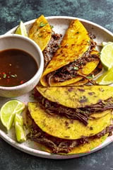 Ein Teller mit Tacos, Fleisch und Zwiebeln.