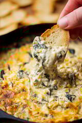 Eine Person hält eine Gabel in eine Schüssel mit Rajas (Creamy Roasted Poblanos) und nimmt einen Bissen.